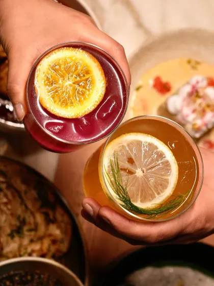 Cheers! Two of our colourful house cocktails, held up for a toast.