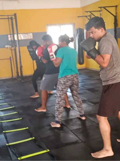 Members practicing their boxing stance and footwork with an agility ladder. Mastering the basics is crucial for effective movement in the ring.