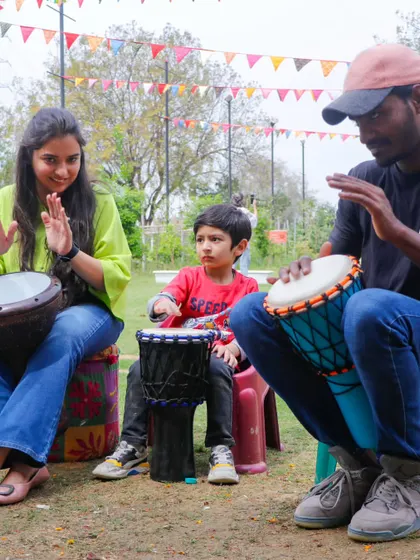 A family enjoying a drum circle session during our Holi carnival.