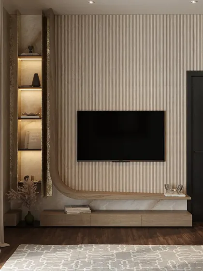 A detailed look at the custom-built TV and shelving unit. The fluted wood texture and curved design create a soft, organic feel, while integrated lighting highlights decorative objects.