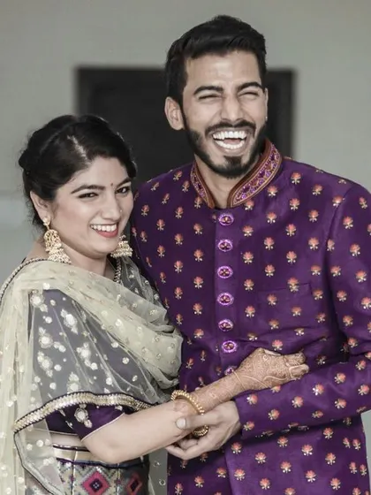 A moment of pure, uninhibited laughter between a couple at their reception. This candid shot perfectly captures their joy and the fun they are having with their loved ones.