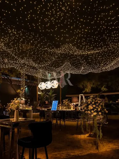 The full view of the sangeet space under the "starry night" ceiling. The thousands of tiny lights create a wave-like effect, making the entire outdoor area feel magical and enclosed.