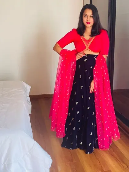 I love a bold color combination. For this client, I designed a striking red crop top and paired it with a deep blue velvet skirt with silver embroidery, completed with a bright pink dupatta.