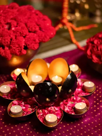 A lotus-shaped candle holder with floating tea lights on a bed of rose petals, a beautiful traditional touch.