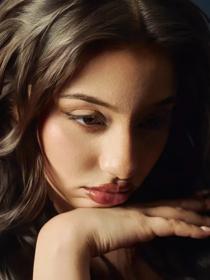 A soft, contemplative beauty portrait. The lighting is gentle and the focus is shallow, creating a dreamy and intimate mood.