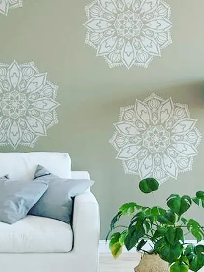Intricate mandala patterns stenciled onto a living room wall. This technique creates a uniform, sophisticated design that adds a tranquil, decorative element to the space.