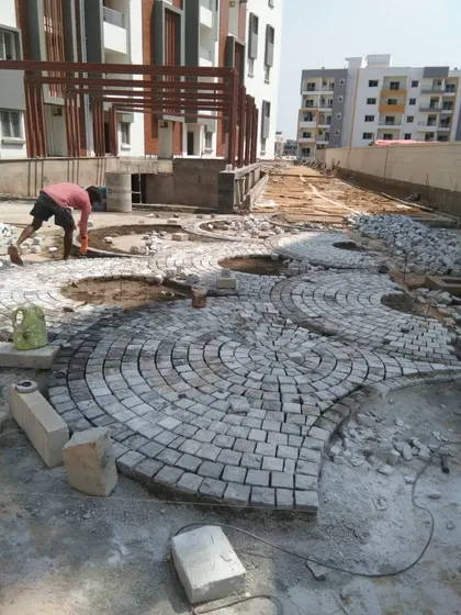 The intricate process of laying a circular cobblestone pattern for a large patio or common area. This image captures the craftsmanship and attention to detail involved in my hardscaping services, which form the durable foundation of any landscape project.