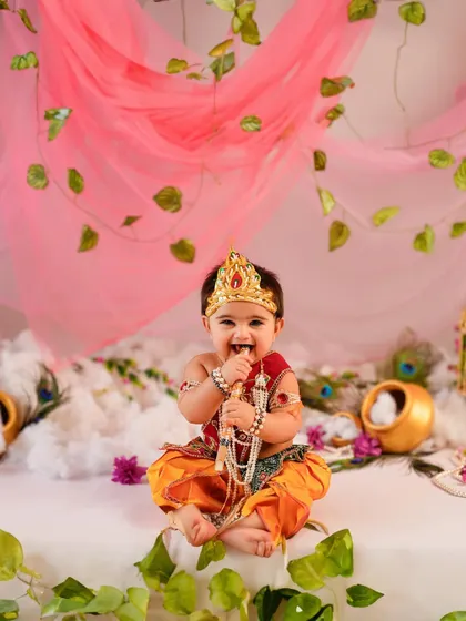 A heart full of joy and a smile that lights up the room. Our themed photoshoots, like this adorable Janmashtami session, are designed to celebrate special occasions and your baby's delightful personality with vibrant, creative setups.