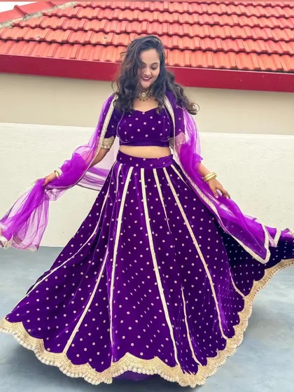 A client celebrating Navaratri in a royal purple lehenga with kali panels and a scalloped gold border. A true festive showstopper.