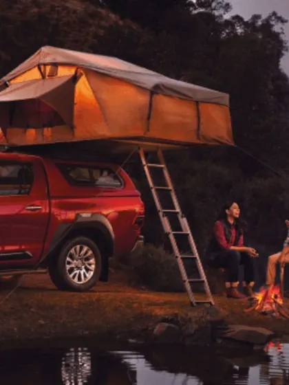 A lifestyle shot for the Toyota Hilux campaign, styled for a camping scenario. The comfortable, layered outdoor wear on the models helps create an authentic scene of enjoying nature with the help of a capable vehicle.