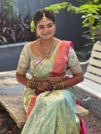 A beautiful outdoor portrait of my bride Ashitha. The natural sunlight highlights the dewy, skin-like finish of her makeup, which complements her pastel Kanchipuram saree.