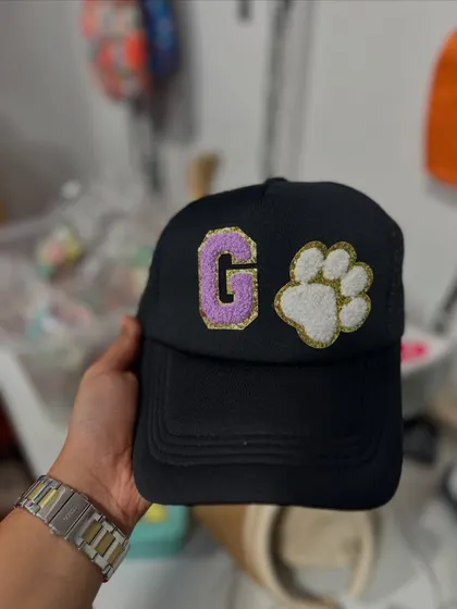 A black cap customized with a 'G' initial and a paw print patch. Perfect for pet lovers or just to add a unique touch to your look.