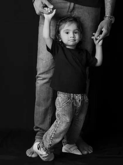 "Hold my hands, Daddy." This shot of a little girl walking with her father is a powerful symbol of guidance and love.