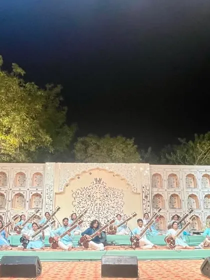 A wide-angle shot of the Sitar Symphony performing at an evening concert in Ahmedabad. The beautiful stage setup and lighting added to the magical atmosphere of the performance.