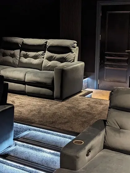 A view from the side, showing the layout of the tiered seating and the entrance door, all designed to feel like a private, exclusive cinema.
