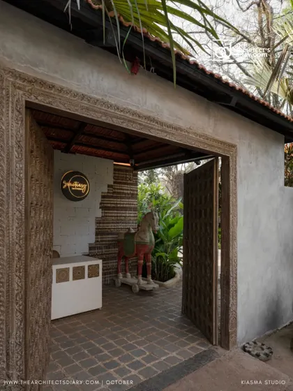 The intricately carved wooden doorway at Sanctuary Bar, offering a glimpse into the reception area. The design blends traditional craftsmanship with a raw, natural aesthetic.