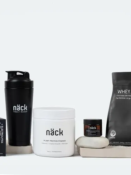 A clean and minimalist product shot for a line of fitness supplements. The monochrome color scheme and geometric arrangement on concrete blocks create a strong, modern, and powerful brand image.