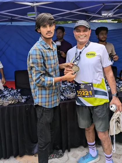 A runner receiving his finisher's medal at the Farmley Snack Run. We believe every finisher is a winner.