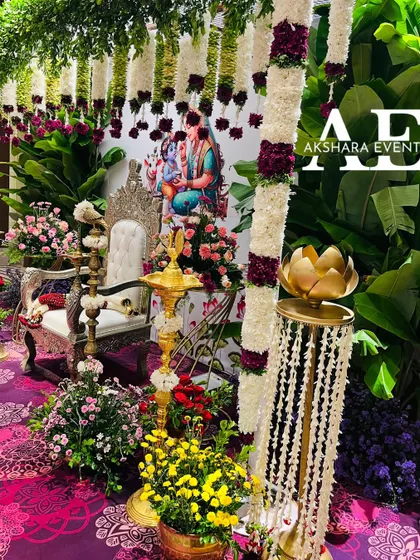 A close-up view of a lush Seemantham setup. This image highlights the details of the hanging garlands, the banana leaf backdrop, and a portrait of Krishna, creating a divine atmosphere.