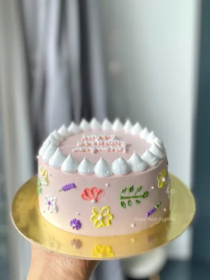 A lovely minimalist cake with delicate hand-piped flowers. The soft colors and simple design make it a charming choice for a birthday.