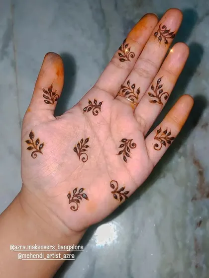 A very simple and dainty design with small leafy motifs scattered on the palm, perfect for a minimalist look.