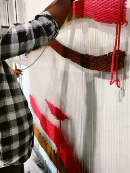 A member of my incredible team weaving the threads for the tapestry installation. It's a meticulous, hands-on process.