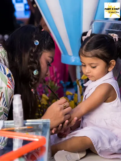 A very young child getting her arm painted. We ensure a comfortable and safe experience for even the tiniest party-goers.