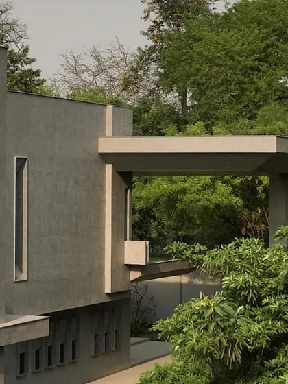 Close-up details of the concrete facade, showing the interplay of sharp angles, deep recesses, and smooth surfaces. These shots emphasize the building's sculptural and tactile qualities.