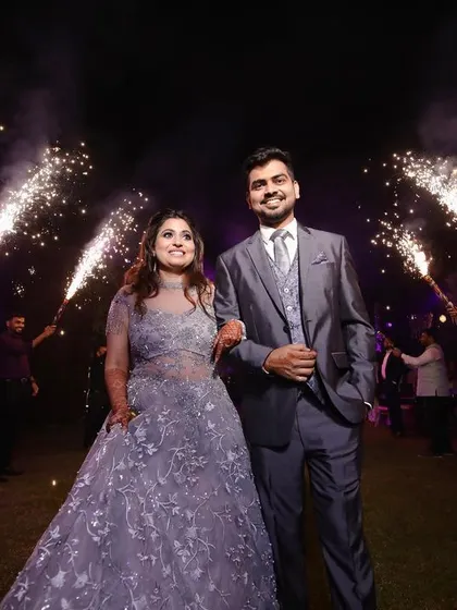 A grand entrance for the newly engaged couple. Surrounded by friends and sparklers, they walk in with bright smiles, ready to celebrate their future together.