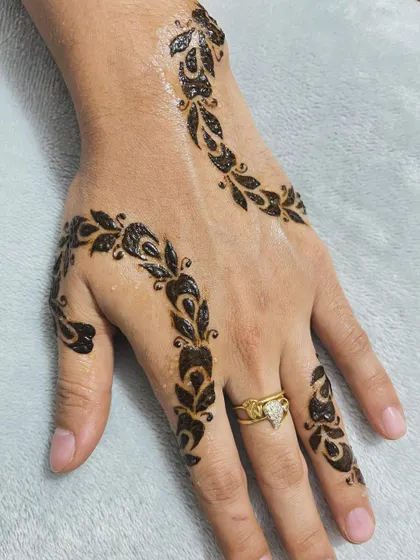 Another angle of the delicate swirling vine pattern, showing the details on the fingers.