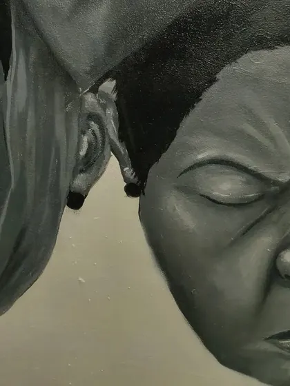 A close-up showing the interaction between two of the faces in the mural. The different expressions, one with eyes closed and one with an eye open, represent different mental states.