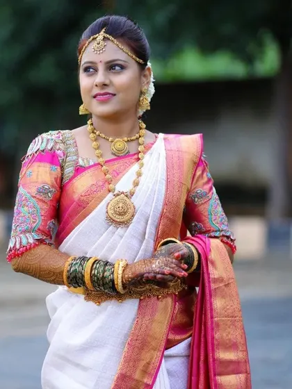 This bride chose a classic combination of a white silk saree with a pink and gold border. I created a matching pink blouse with beautiful paisley-inspired embroidery on the sleeves.