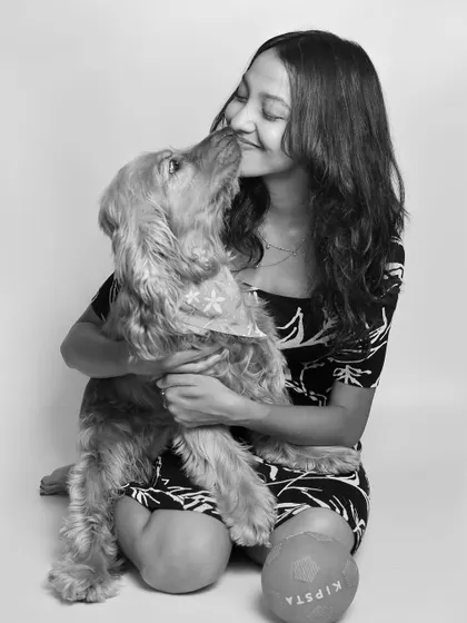 A gentle nuzzle from a sweet Cocker Spaniel. This intimate black and white portrait captures the quiet, loving bond between a girl and her dog.