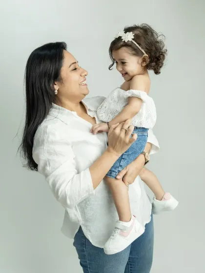 A beautiful, candid moment between a mother and her daughter, sharing a laugh during their family session.