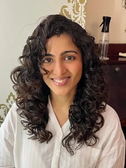 Curly layers for Aishwarya to create definition and volume in her medium-length hair.