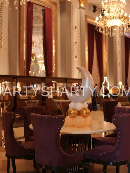 A moon-shaped foil balloon centerpiece, continuing the celestial teddy bear theme throughout the venue.