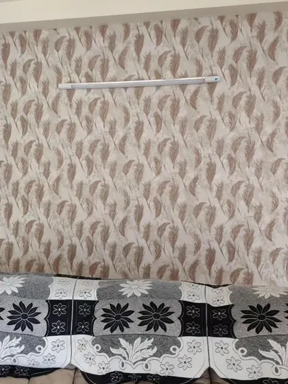 A living room wall with a repeating feather pattern. The neutral color scheme makes it a versatile choice that complements the existing furniture.