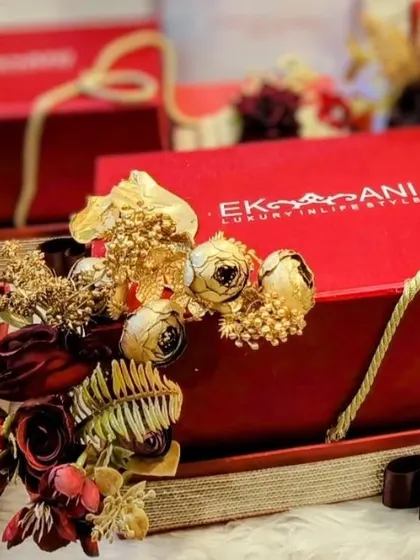 A full view of the first card presentation hamper. The red tray is decorated with rich, dry florals in gold and maroon, perfectly complementing the luxurious gift box from Ekaani.