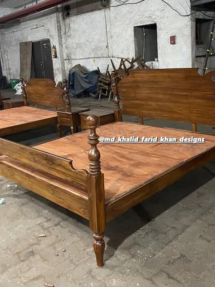 Detailed view of the headboard and footboard of a colonial-style bed, showcasing the quality of the wood and the classic design elements.