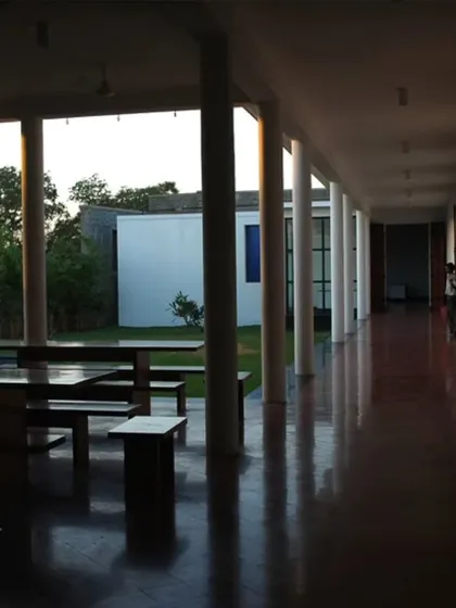 The shaded verandah at the Synergy factory serves as a transition space and a place for workers to rest. The deep red oxide flooring and rhythmic columns create a calming corridor that connects the indoor workspace with the outdoor landscape.