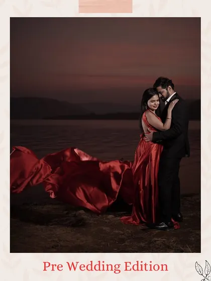A moody and romantic pre-wedding shot by the water. The deep red of the gown adds a touch of passion and elegance, perfectly complementing the groom's dark suit.