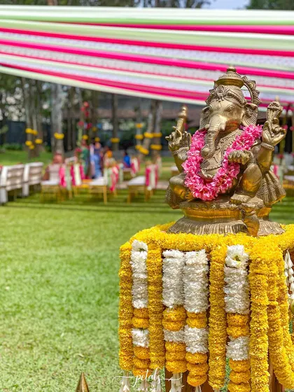 A Ganesha idol is the centerpiece of this traditional decor, surrounded by garlands of marigolds and chrysanthemums.