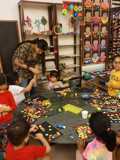 My toddlers are creating their own versions of African Kente cloth patterns using colorful paper collage. It's a great introduction to geometric art.
