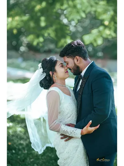 A romantic embrace during a Christian wedding photoshoot. The bride's veil catching the breeze adds a touch of ethereal beauty.