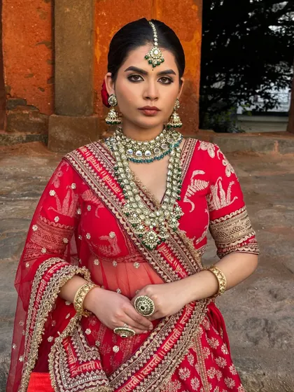 Another shot of the beautiful red lehenga look. The makeup is classic and timeless, with a focus on flawless skin and defined eyes.
