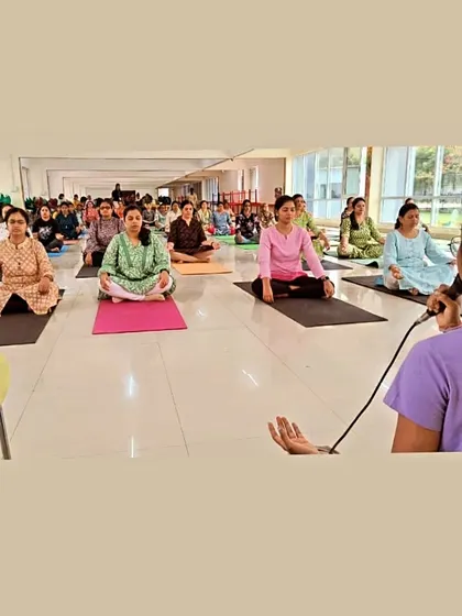 Leading a guided meditation from the front of the class, helping everyone to settle in and find their inner quiet.