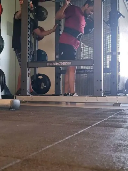 Guiding a client through a squat session. My role as a coach is to ensure safety, proper technique, and motivation.