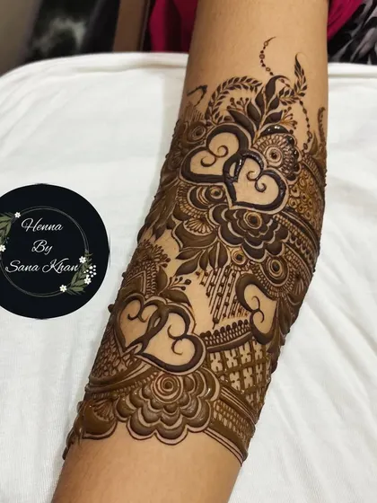 A close-up of an arm design featuring interlocking hearts, a beautiful and romantic element perfect for any bride.