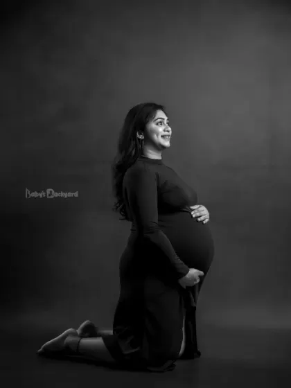 A powerful and beautiful silhouette. This black and white kneeling portrait highlights the amazing shape of the baby bump and the strength of the mother-to-be.