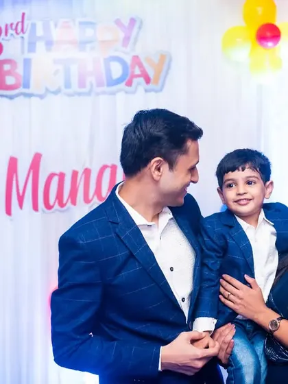 A loving family portrait from a third birthday celebration. The way the parents and child are looking at each other creates a beautiful, connected moment.